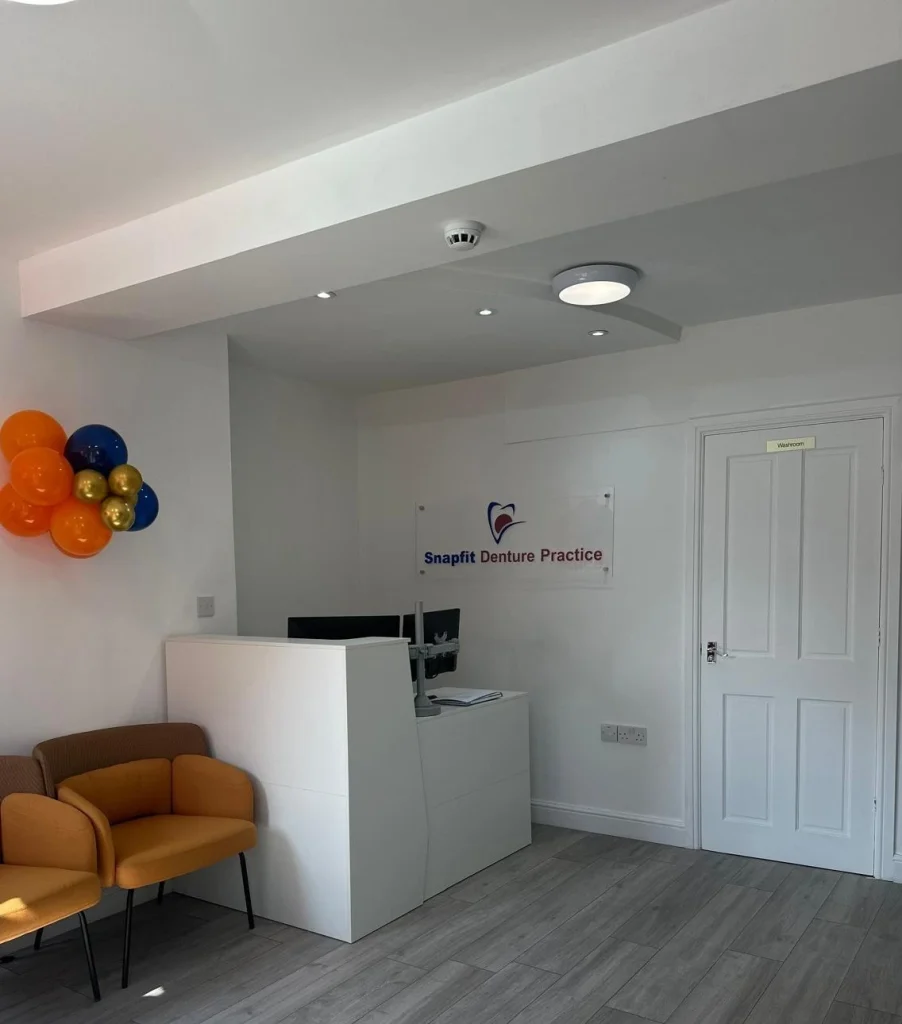 Reception area at SnapFit Denture Practice in Wolverhampton, showing branded signage and waiting seating