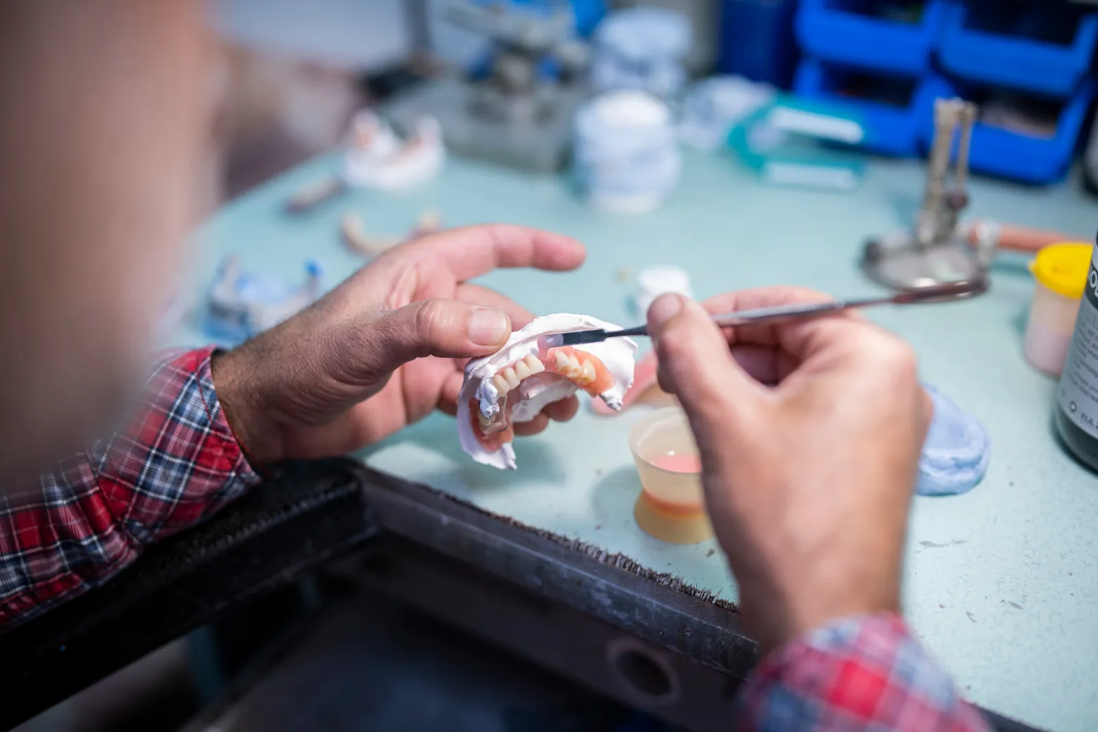 Dental technician repairing a cracked denture in an on-site lab